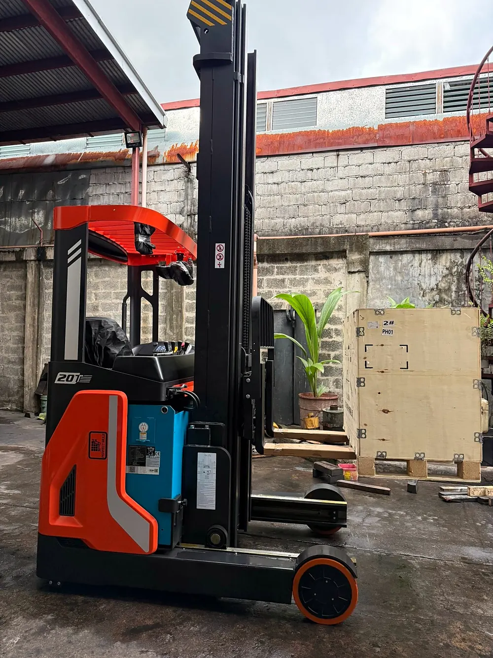 New Perfect Mule reach truck with its mast raised, next to a wooden shipping crate