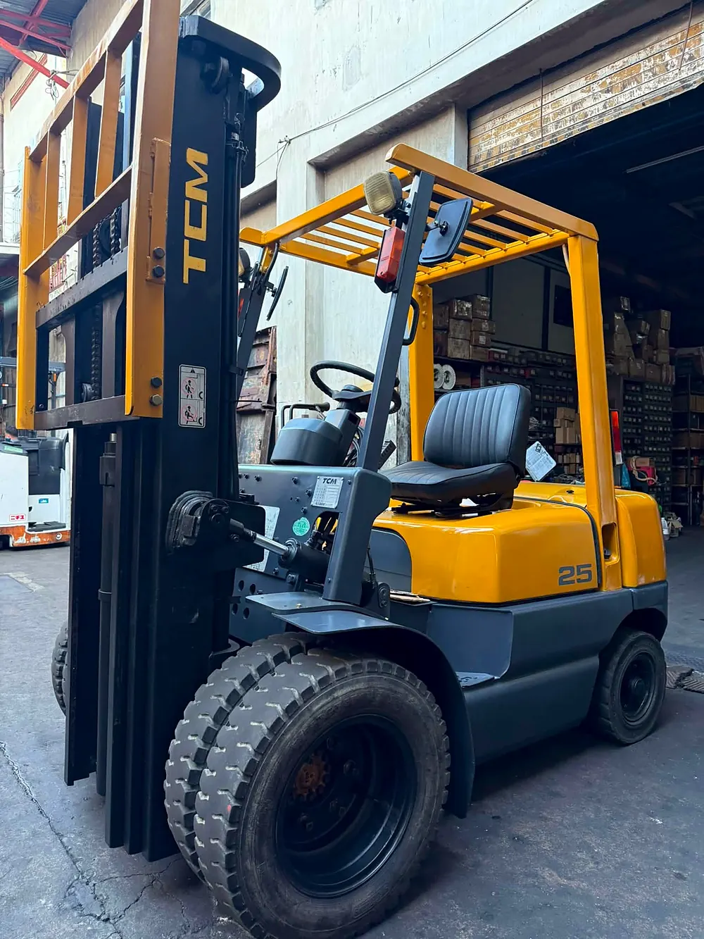 TCM 25 forklift parked in front of shelves of boxed parts in the stockroom
